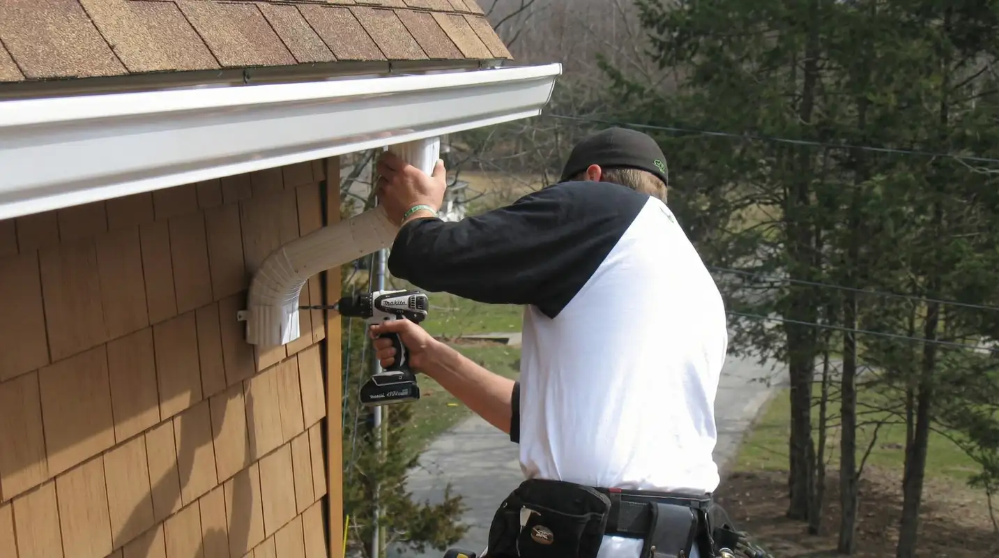 Professional contractor installing tan vinyl siding panels on a residential home exterior in Fresno, CA